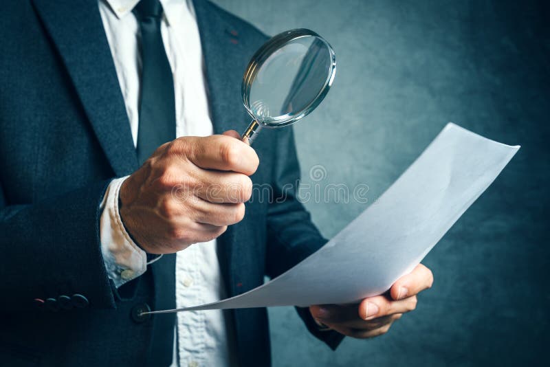 Φορολογικός επιθεωρητής που τα οικονομικά έγγραφα μέσω του magnifyi στοκ φωτογραφία με δικαίωμα ελεύθερης χρήσης