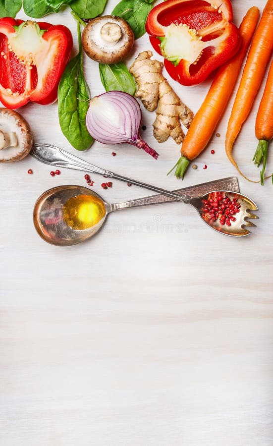 Fresh vegetables for Healthy cooking with spoons,oil and spices on light wooden background, top view. Vegan or clean diet food concept. Fresh vegetables for Healthy cooking with spoons,oil and spices on light wooden background, top view. Vegan or clean diet food concept.