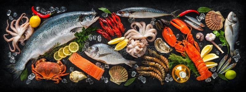 Fresh fish and seafood arrangement on black stone background. Fresh fish and seafood arrangement on black stone background