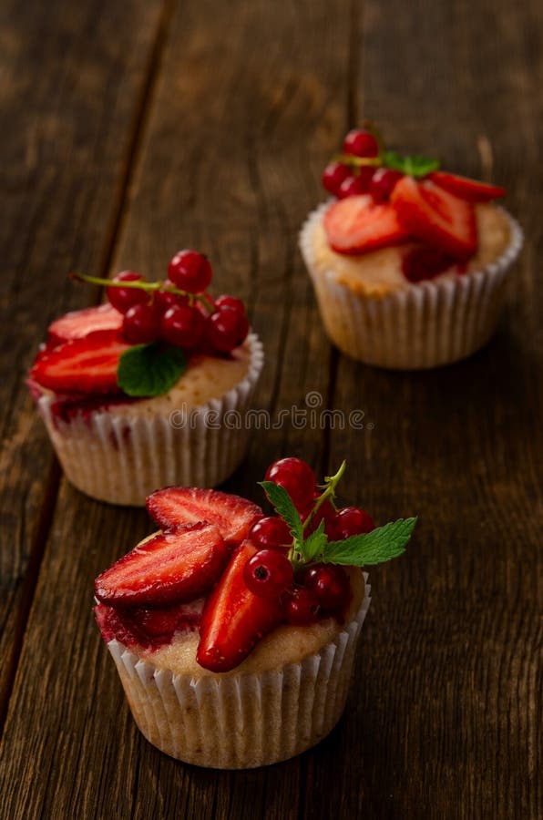 Φρέσκα φρούτα φραουλών σπιτικά muffins που διακοσμούνται πέρα από με τα φύλλα μεντών στοκ εικόνες με δικαίωμα ελεύθερης χρήσης Φρέσκα φρούτα φραουλών σπιτικά muffins που διακοσμούνται πέρα από με τα φύλλα μεντών στοκ εικόνες με δικαίωμα ελεύθερης χρήσης