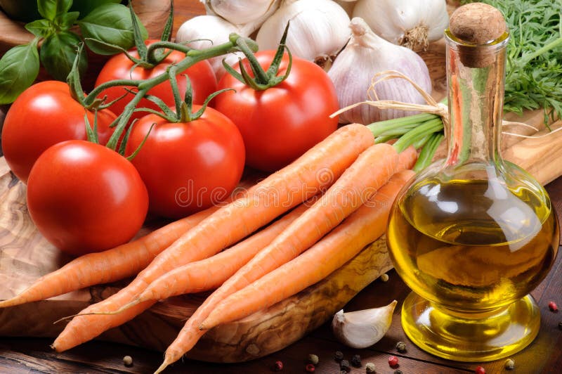 Fresh tomatoes, carrot and olive oil on the wooden cutting board. Fresh tomatoes, carrot and olive oil on the wooden cutting board