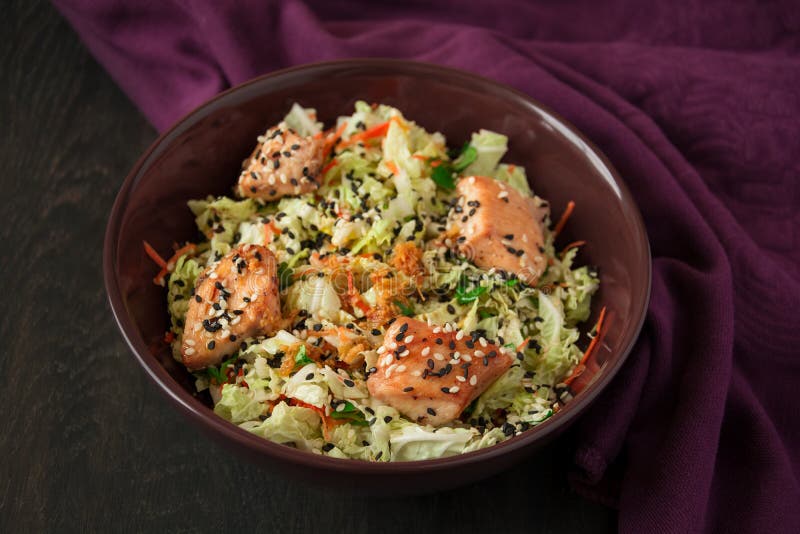 Fresh salad with napa cabbage, carrot, chicken, cilantro and sesame seeds on dark wooden table. Fresh salad with napa cabbage, carrot, chicken, cilantro and sesame seeds on dark wooden table