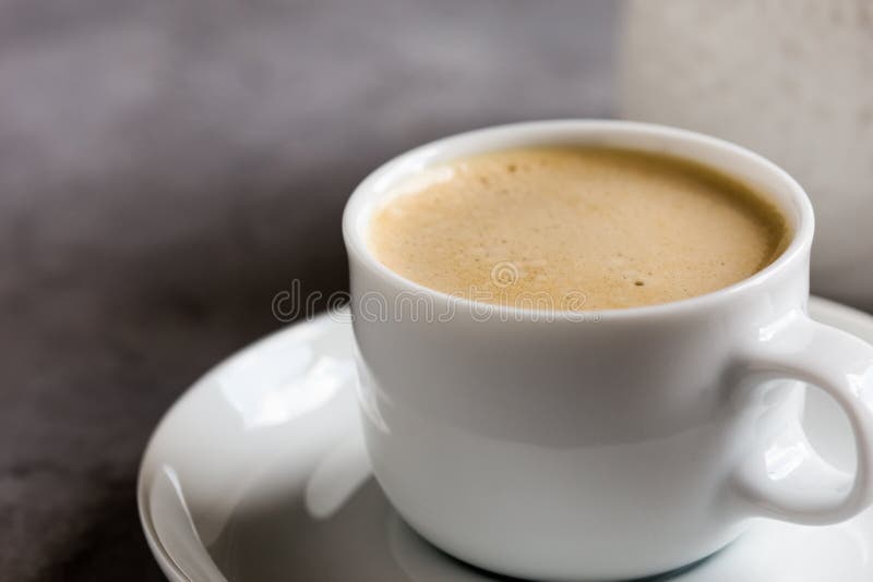 Fresh cappuccino, traditional espresso coffee drink with milk, cup of delicious morning treat on grey background. Fresh cappuccino, traditional espresso coffee drink with milk, cup of delicious morning treat on grey background
