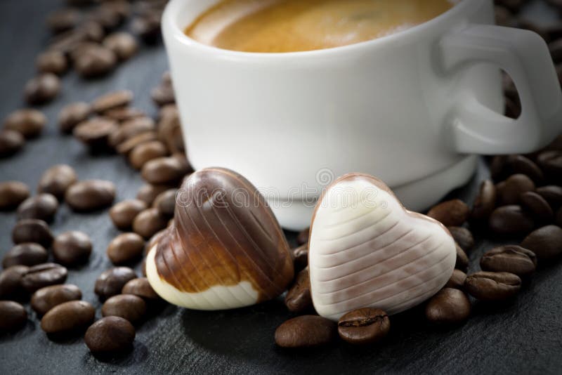 Fresh espresso, coffee beans and chocolate candies in a heart shape, selective focus, close-up. Fresh espresso, coffee beans and chocolate candies in a heart shape, selective focus, close-up