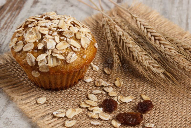 Φρέσκο muffin με oatmeal που ψήνεται με το wholemeal αλεύρι και τα αυτιά του σιταριού σίκαλης, εύγευστο υγιές επιδόρπιο στοκ φωτογραφία Φρέσκο muffin με oatmeal που ψήνεται με το wholemeal αλεύρι και τα αυτιά του σιταριού σίκαλης, εύγευστο υγιές επιδόρπιο στοκ φωτογραφία