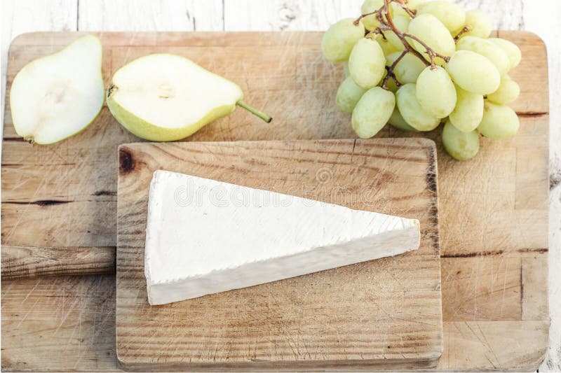 Φρέσκο τυρί της Brie στον τέμνοντα πίνακα με τα σταφύλια και τα φρούτα, κορυφή στοκ εικόνες με δικαίωμα ελεύθερης χρήσης Φρέσκο τυρί της Brie στον τέμνοντα πίνακα με τα σταφύλια και τα φρούτα, κορυφή στοκ εικόνες με δικαίωμα ελεύθερης χρήσης