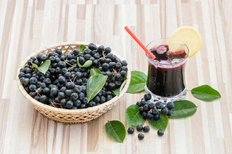 Φρέσκος χυμός του chokeberry ή melanocarpa Aronia στο γυαλί με τον πάγο, το λεμόνι και το άχυρο στοκ εικόνες με δικαίωμα ελεύθερης χρήσης Φρέσκος χυμός του chokeberry ή melanocarpa Aronia στο γυαλί με τον πάγο, το λεμόνι και το άχυρο στοκ εικόνες με δικαίωμα ελεύθερης χρήσης