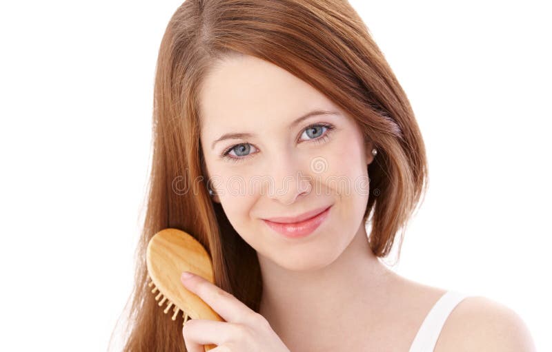 Natural beauty ginger girl combing hair, smiling at camera. Natural beauty ginger girl combing hair, smiling at camera.