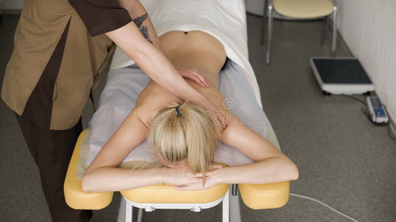 Φυσιοθεραπευτής που κάνει το μασάζ λαιμών στον ασθενή του στο ιατρικό γραφείο