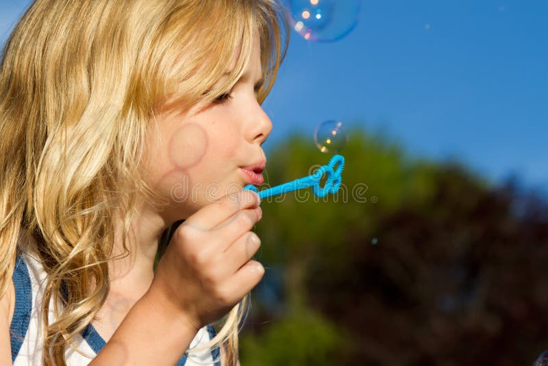 A little girl blowing bubbles in the garden. A little girl blowing bubbles in the garden.