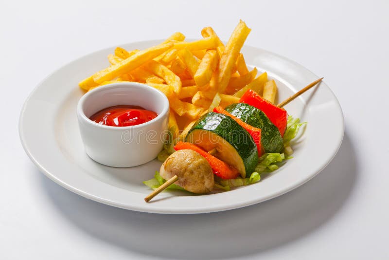 Φυτικό kebab ψημένα στη σχάρα λαχανικά οβελίδια στο πιάτο με τις τηγανιτές πατάτες στοκ εικόνες Φυτικό kebab ψημένα στη σχάρα λαχανικά οβελίδια στο πιάτο με τις τηγανιτές πατάτες στοκ εικόνες
