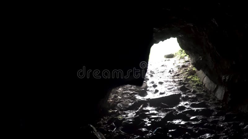 Φωτεινό ηλιακό φως στην έξοδο της σκούρας σπηλιάς, μυστικιστική φύση Υλικό μετοχών Υλικό μετοχών Προβολή από το εσωτερικό της