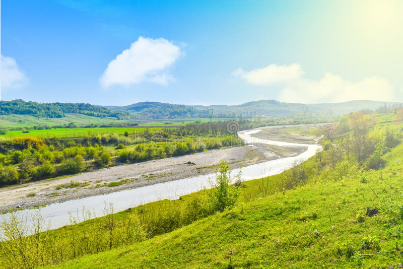 Φωτεινός λάμποντας ποταμός στην πράσινη κοιλάδα με την πράσινη χλόη και μπλε ουρανός σε θερινό ηλιόλουστο ημερησίως Θερινό τοπίο στοκ φωτογραφίες Φωτεινός λάμποντας ποταμός στην πράσινη κοιλάδα με την πράσινη χλόη και μπλε ουρανός σε θερινό ηλιόλουστο ημερησίως Θερινό τοπίο στοκ φωτογραφίες