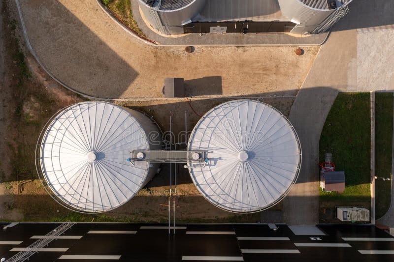 Drone photography of 2 large tubular steel tanks in a warehouse complex during summer day. Drone photography of 2 large tubular steel tanks in a warehouse complex during summer day