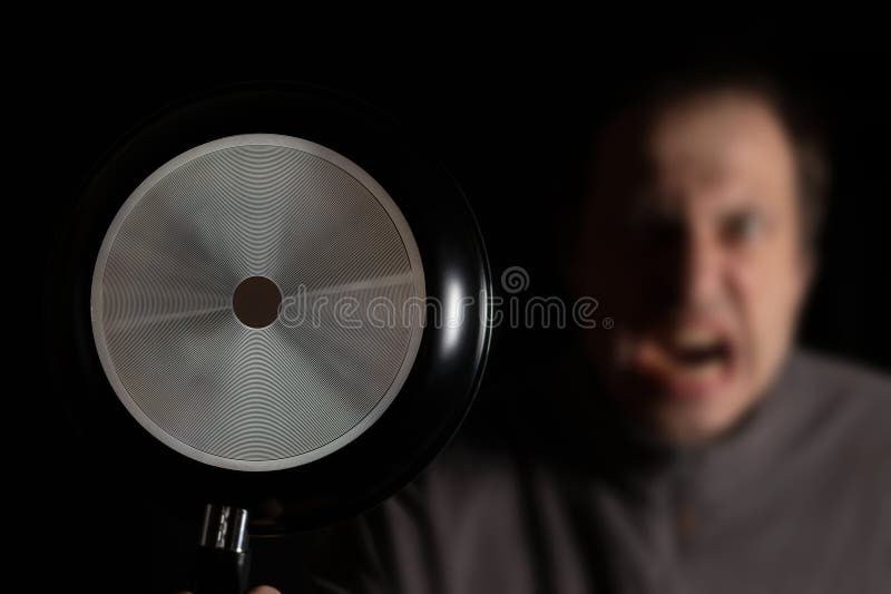 φωτογραφία ενός τρελού οργισμένου οργισμένου άντρα που κρατά το τηγάνι της κουζίνας στοκ φωτογραφία