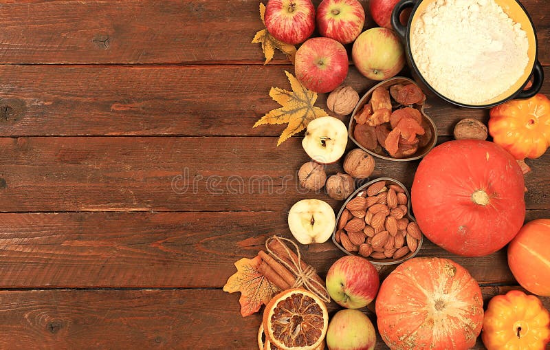 Kitchen background with pumpkin, apples, spices, nuts, flour, eggs with place for menu, cooking concept, ingredients for pumpkin and apple pies recipe, selective focus, top view, space for text. Kitchen background with pumpkin, apples, spices, nuts, flour, eggs with place for menu, cooking concept, ingredients for pumpkin and apple pies recipe, selective focus, top view, space for text