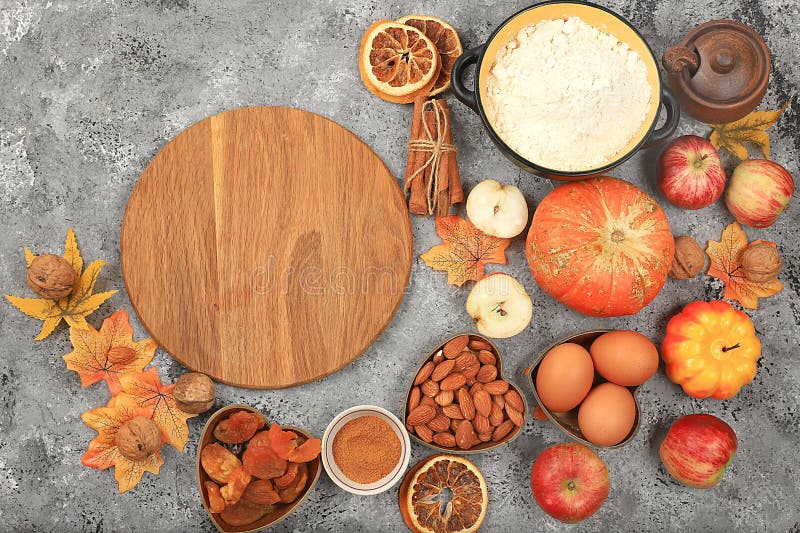 Kitchen background with pumpkin, apples, spices, nuts, flour, eggs with place for menu, cooking concept, ingredients for pumpkin and apple pies recipe, selective focus, top view, space for text. Kitchen background with pumpkin, apples, spices, nuts, flour, eggs with place for menu, cooking concept, ingredients for pumpkin and apple pies recipe, selective focus, top view, space for text