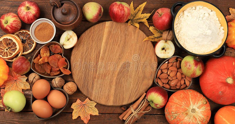 Kitchen background with ingredients for pumpkin and apple pies recipe, food preparation concept, cooking pies with spices, nuts, flour, eggs and pumpkin, apples for Thanksgiving, selective focus, top view, space for text. Kitchen background with ingredients for pumpkin and apple pies recipe, food preparation concept, cooking pies with spices, nuts, flour, eggs and pumpkin, apples for Thanksgiving, selective focus, top view, space for text