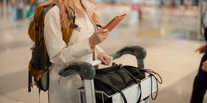 χέρι γυναίκας επιβάτη που κρατά διαβατήριο με την πτήση στο αεροδρόμιο στοκ εικόνα