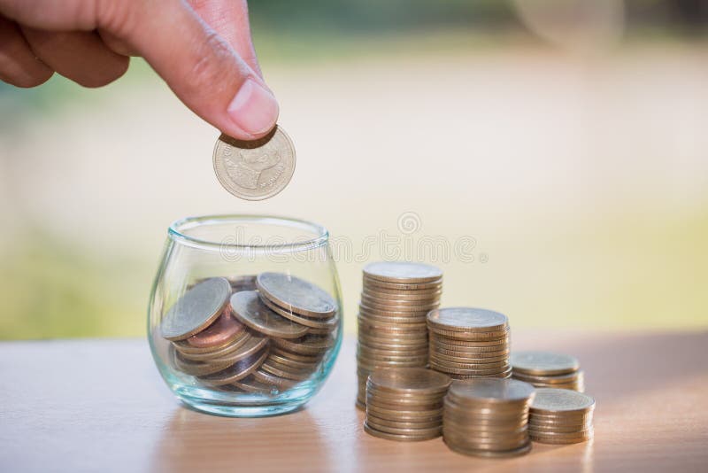 Χέρι γυναικών που βάζει coinIn το βάζο γυαλιού Πλούτος χρημάτων αποταμίευσης και στοκ εικόνες Χέρι γυναικών που βάζει coinIn το βάζο γυαλιού Πλούτος χρημάτων αποταμίευσης και στοκ εικόνες