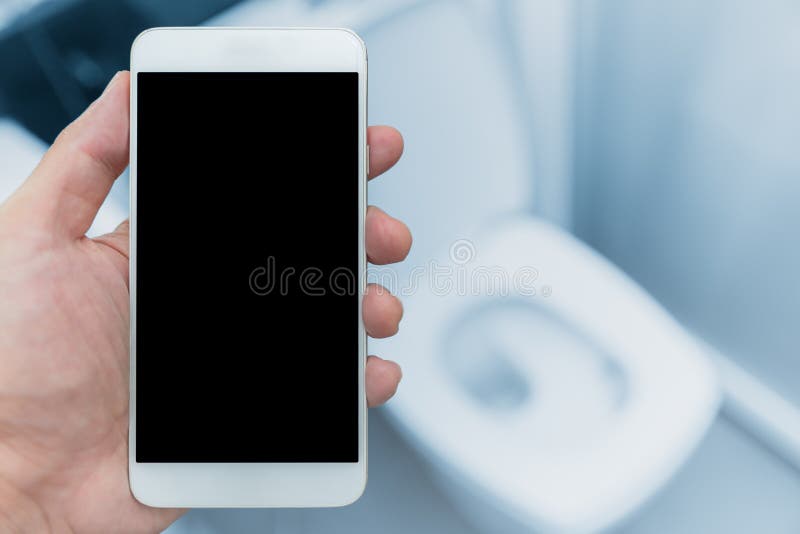 Χέρι με το smartphone στο υπόβαθρο ντουλαπιών τουαλετών στοκ εικόνα Χέρι με το smartphone στο υπόβαθρο ντουλαπιών τουαλετών στοκ εικόνα