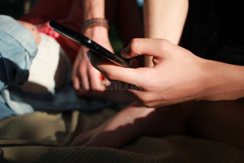 χέρια ενός έφηβου αγοριού με τηλέφωνο. πληκτρολόγηση σε έξυπνο τηλέφωνο σε εξωτερικό χώρο. κλείσιμο στοκ φωτογραφία με δικαίωμα ελεύθερης χρήσης