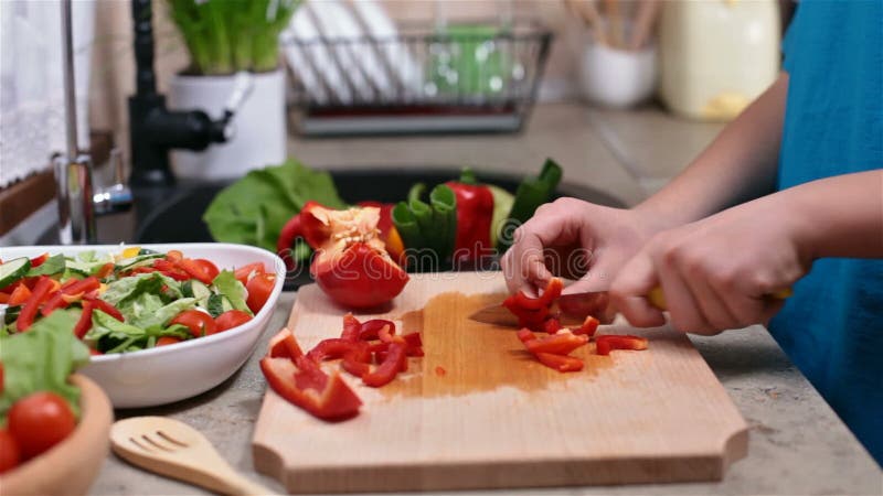 Χέρια παιδιών που τεμαχίζουν ένα κόκκινο bellpepper - πλάγια όψη απόθεμα βίντεο