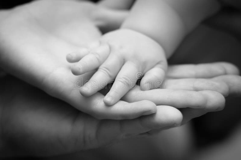 Χέρια πατέρων, μητέρων και μωρών ` s μαζί σε γραπτό στοκ εικόνες