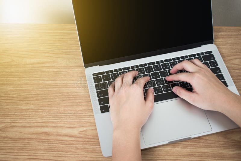 Χέρια στο lap-top στον καφετή ξύλινο πίνακα στο δωμάτιο στοκ φωτογραφίες με δικαίωμα ελεύθερης χρήσης Χέρια στο lap-top στον καφετή ξύλινο πίνακα στο δωμάτιο στοκ φωτογραφίες με δικαίωμα ελεύθερης χρήσης