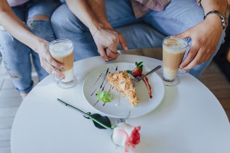 Χέρια της αγάπης σε ένα ζεύγος και latte στοκ εικόνες Χέρια της αγάπης σε ένα ζεύγος και latte στοκ εικόνες