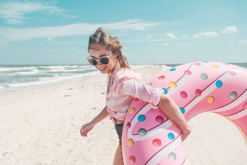 Χαλάρωση κοριτσιών doughnut στο lilo στην παραλία στοκ φωτογραφίες Χαλάρωση κοριτσιών doughnut στο lilo στην παραλία στοκ φωτογραφίες