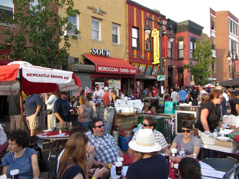 Photo of crowd of people relaxing at the h street festival in downtown washington dc on 9/15/12. This festival takes place every year in mid september with food, arts and crafts, music, a parade, car displays, free health screenings and dance. The h street neighborhood is undergoing revitalization. Photo of crowd of people relaxing at the h street festival in downtown washington dc on 9/15/12. This festival takes place every year in mid september with food, arts and crafts, music, a parade, car displays, free health screenings and dance. The h street neighborhood is undergoing revitalization.