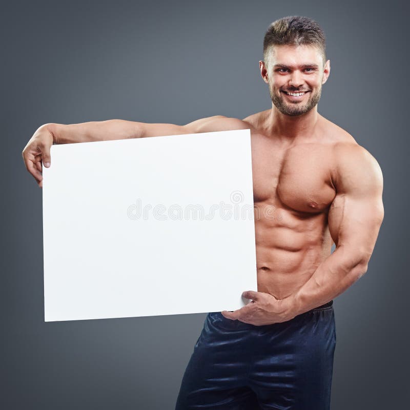 Χαμογελώντας bodybuilder κενή άσπρη αφίσα εκμετάλλευσης στοκ φωτογραφίες Χαμογελώντας bodybuilder κενή άσπρη αφίσα εκμετάλλευσης στοκ φωτογραφίες
