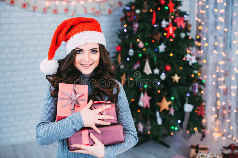 Χαμογελώντας γυναίκα στο καπέλο Santa με πολλά κιβώτια δώρων στοκ φωτογραφία Χαμογελώντας γυναίκα στο καπέλο Santa με πολλά κιβώτια δώρων στοκ φωτογραφία