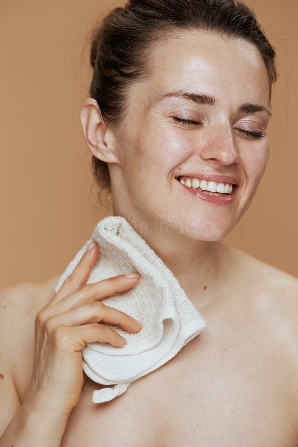 χαμογελαστή γυναίκα με πρόσωπο που πλένει την πετσέτα