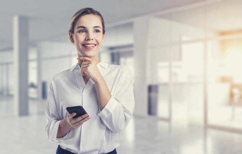 χαμογελαστή νεαρή επιχειρηματίας με smartphone στο γραφείο στοκ φωτογραφίες με δικαίωμα ελεύθερης χρήσης