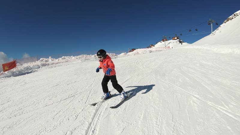 χαμογελαστό παιδί σκι και χέρι που χαιρετά στο χιόνι