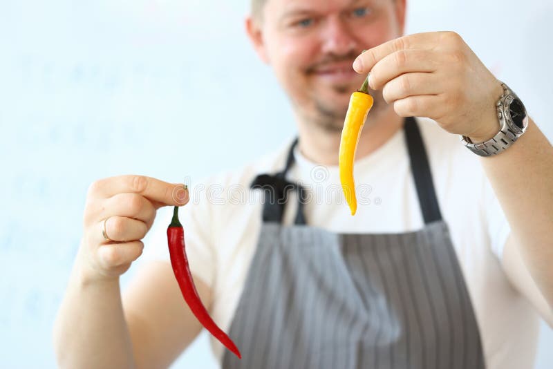 Χαμογελώντας αρχιμαγείρων πιπέρι του Cayenne εκμετάλλευσης κόκκινο οργανικό στοκ φωτογραφία Χαμογελώντας αρχιμαγείρων πιπέρι του Cayenne εκμετάλλευσης κόκκινο οργανικό στοκ φωτογραφία
