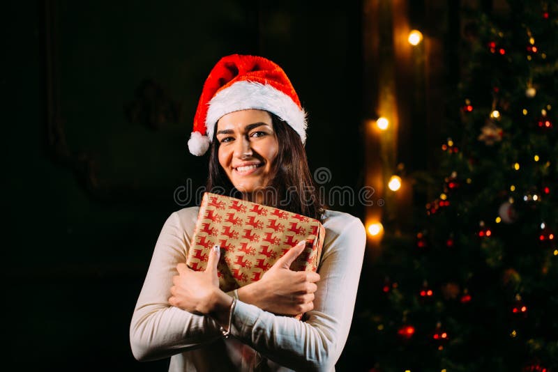 Χαμογελώντας γυναίκα στο καπέλο αρωγών santa με πολλά κιβώτια δώρων στοκ φωτογραφίες Χαμογελώντας γυναίκα στο καπέλο αρωγών santa με πολλά κιβώτια δώρων στοκ φωτογραφίες