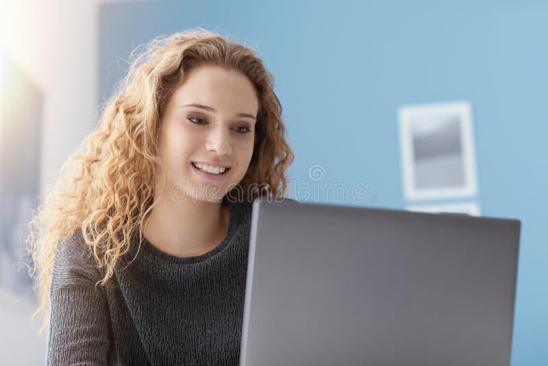 Χαμογελώντας κορίτσι που συνδέει με το lap-top της στοκ εικόνες Χαμογελώντας κορίτσι που συνδέει με το lap-top της στοκ εικόνες