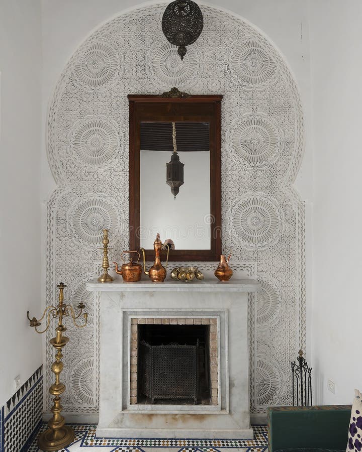 Pictured is a carved wooden mosaic with arabic geometric patterns sound a small marble fireplace and mirror at the Riad Maison Bleue, a luxury boutique hotel in Fes, Morocco. The Riad Maison Bleue was created in a house dating from the 19th century whose former owner, was the late Moulay Bel Arbi El Alaoui, famous judge and professor of theology. Today the luxury boutique hotel it is managed by the El Abbadi`s family. Pictured is a carved wooden mosaic with arabic geometric patterns sound a small marble fireplace and mirror at the Riad Maison Bleue, a luxury boutique hotel in Fes, Morocco. The Riad Maison Bleue was created in a house dating from the 19th century whose former owner, was the late Moulay Bel Arbi El Alaoui, famous judge and professor of theology. Today the luxury boutique hotel it is managed by the El Abbadi`s family.