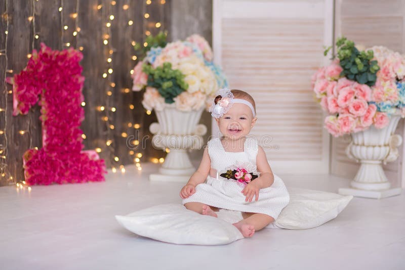 Cute baby girl 1-2 year old sitting on floor with pink balloons in room over white. Isolated. Birthday party. Celebration. Happy birthday baby, Little girl with group ball. Play room. Cute baby girl 1-2 year old sitting on floor with pink balloons in room over white. Isolated. Birthday party. Celebration. Happy birthday baby, Little girl with group ball. Play room