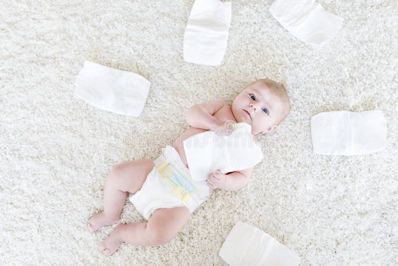 Cute adorable newborn baby of 3 moths with diapers. Hapy tiny little girl or boy looking at the camera. Dry and healthy body and skin for children concept. Baby nursery. Cute adorable newborn baby of 3 moths with diapers. Hapy tiny little girl or boy looking at the camera. Dry and healthy body and skin for children concept. Baby nursery