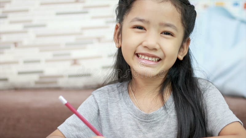 Χαριτωμένο ασιατικό μικρό κορίτσι που χαμογελά με την ευτυχία με τη διαστημική σύνθεση αντιγράφων