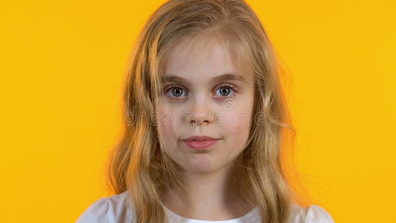 Χαριτωμένο κορίτσι με τα μεγάλα μάτια που εξετάζει τη κάμερα, παιδική ηλικία, απομονωμένο υπόβαθρο