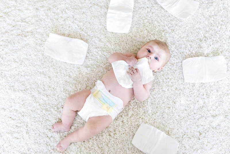 Cute adorable newborn baby of 3 moths with diapers. Hapy tiny little girl or boy looking at the camera. Dry and healthy body and skin for children concept. Baby nursery. Cute adorable newborn baby of 3 moths with diapers. Hapy tiny little girl or boy looking at the camera. Dry and healthy body and skin for children concept. Baby nursery