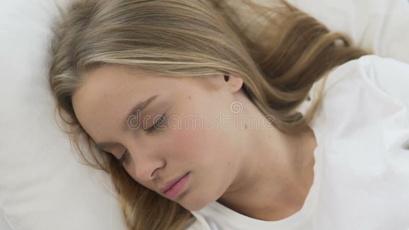 Χαριτωμένος ύπνος κοριτσιών άνετα στο μαλακό κρεβάτι linens, ήρεμη και ήρεμη τοπ άποψη ονείρου