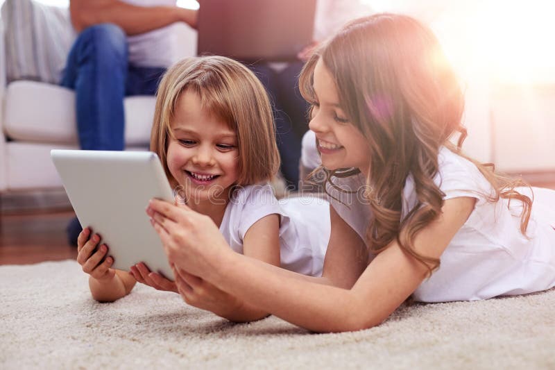 χαρούμενα κορίτσια με υπολογιστή tablet στο σπίτι στοκ εικόνες
