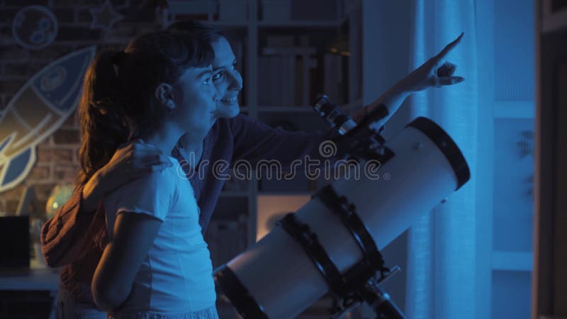 χαρούμενες αδερφές που βλέπουν αστέρια με τηλεσκόπιο