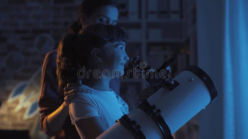χαρούμενες αδερφές που βλέπουν αστέρια με τηλεσκόπιο